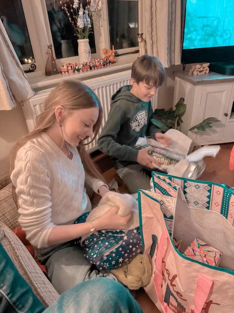 Children opening wrapped Christmas presents on Christmas morning