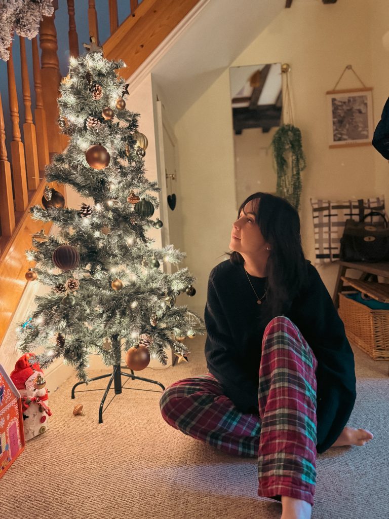 Woman wearing British Boxers red green tartan Christmas pyjama trousers cosy home lifestyle